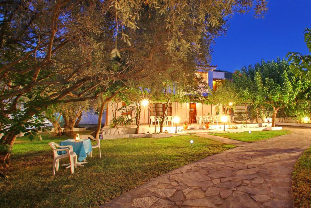 a house with a table and chairs in the yard at night at Korali Stafilos in Stafylos