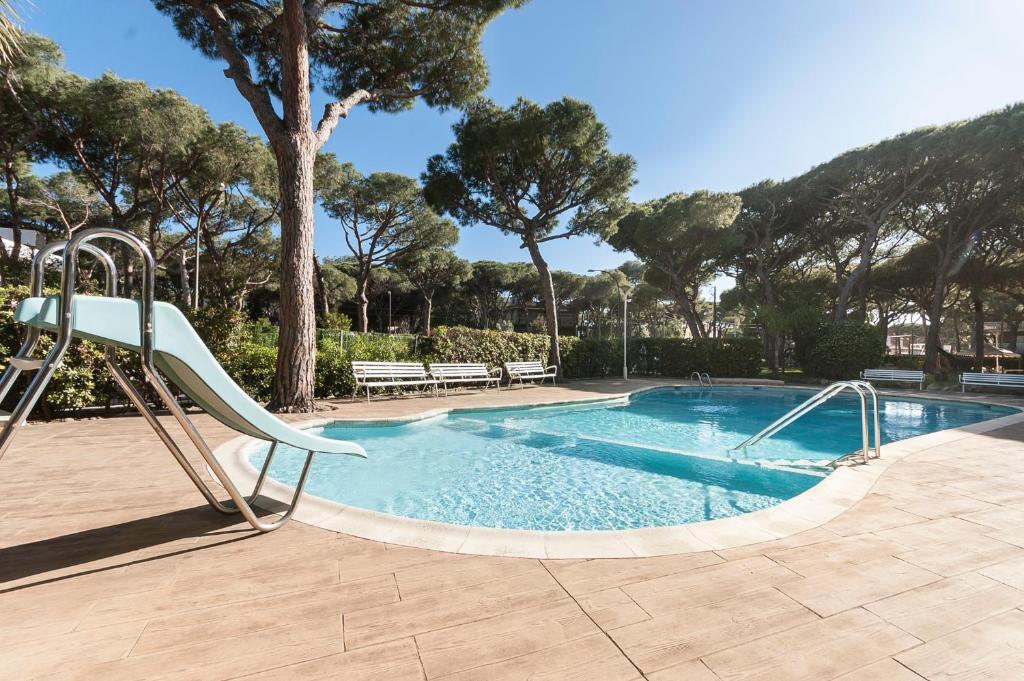 una piscina con un tobogán y una piscina en Lets Holidays Castelldefels Diagonal Orient, en Castelldefels