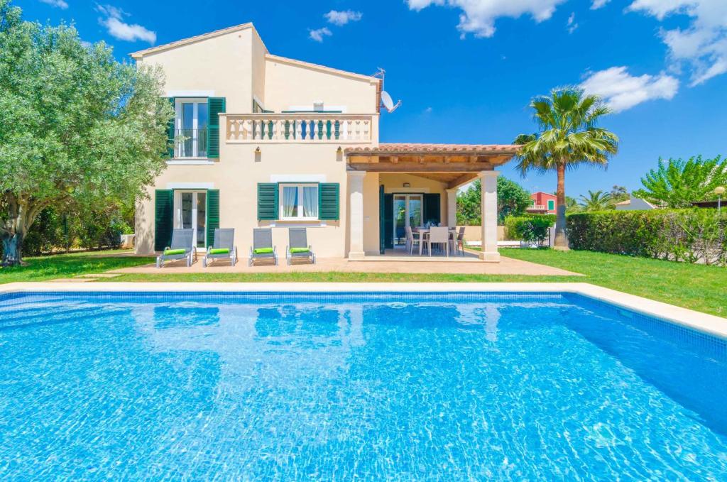 uma villa com piscina em frente a uma casa em Voltora em Sa Ràpita