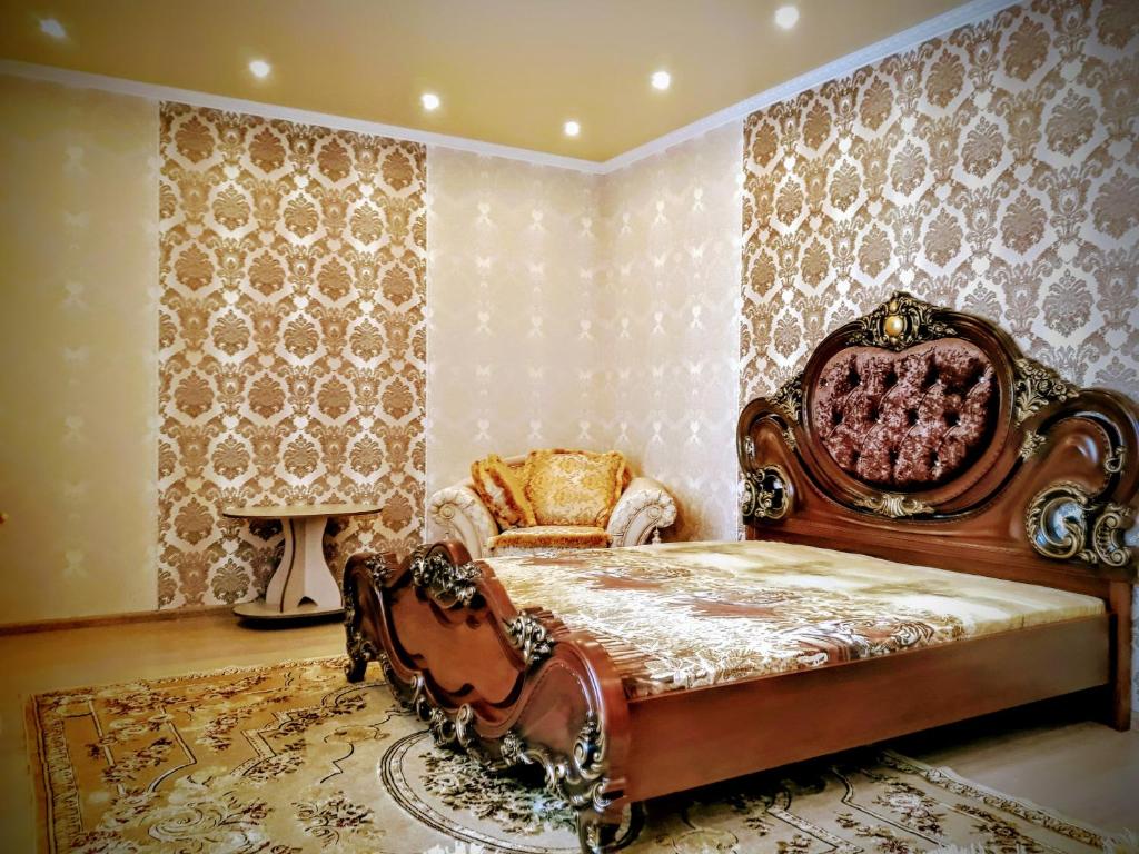 バルナウルにあるЛЮКС Трц Огни А Петрова 221гのベッドルーム(大型ベッド1台、椅子付)