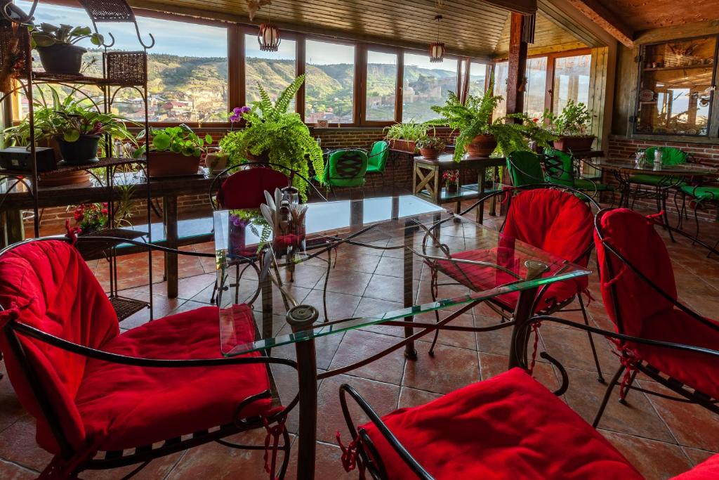 a room with red chairs and tables and windows at Penthouse Hotel in Tbilisi City