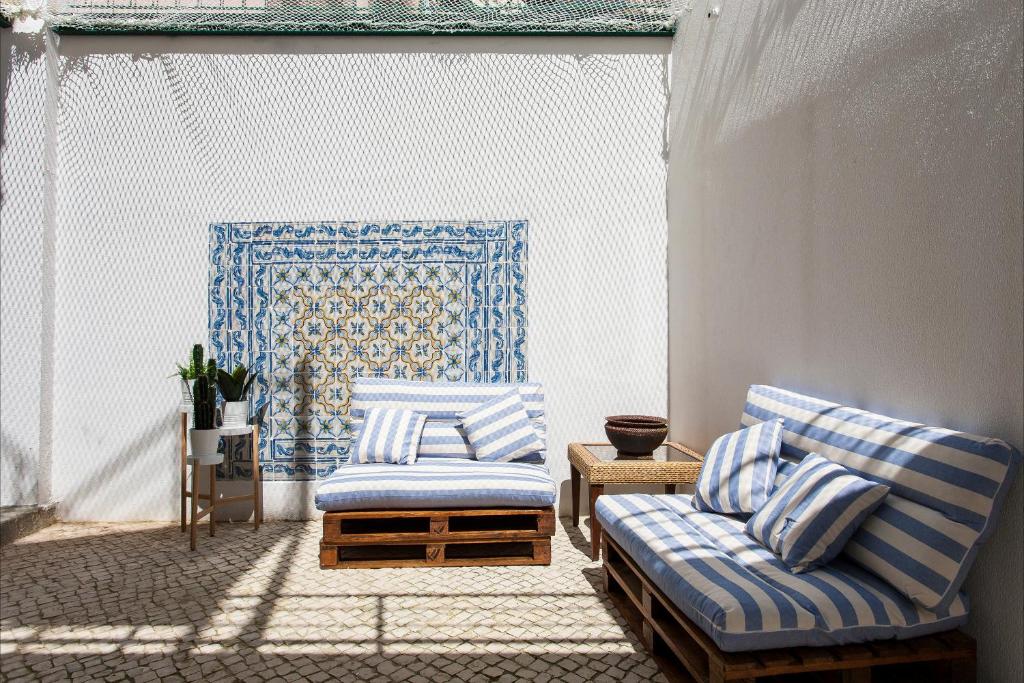 リスボンにあるCaraujo Apartmentsの青と白の椅子2脚と壁が備わる客室です。