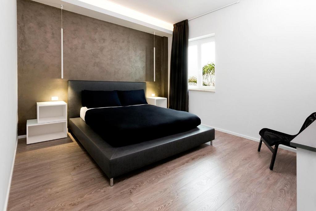 ガリポリにあるMinimal Roomsのベッドルーム(黒いベッド1台、椅子付)