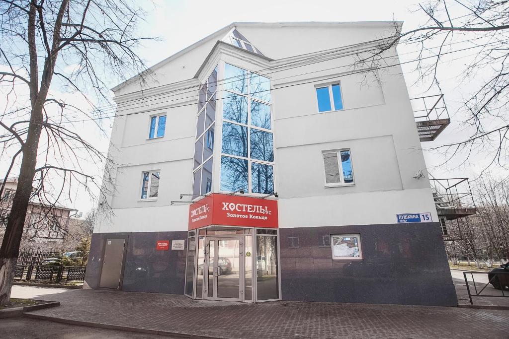 um edifício branco alto com uma loja em frente em Hostel Zolotoye Koltso em Yaroslavl