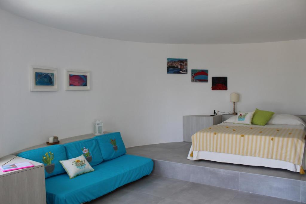 a bedroom with a bed and a blue couch at La Rotonda in Anacapri