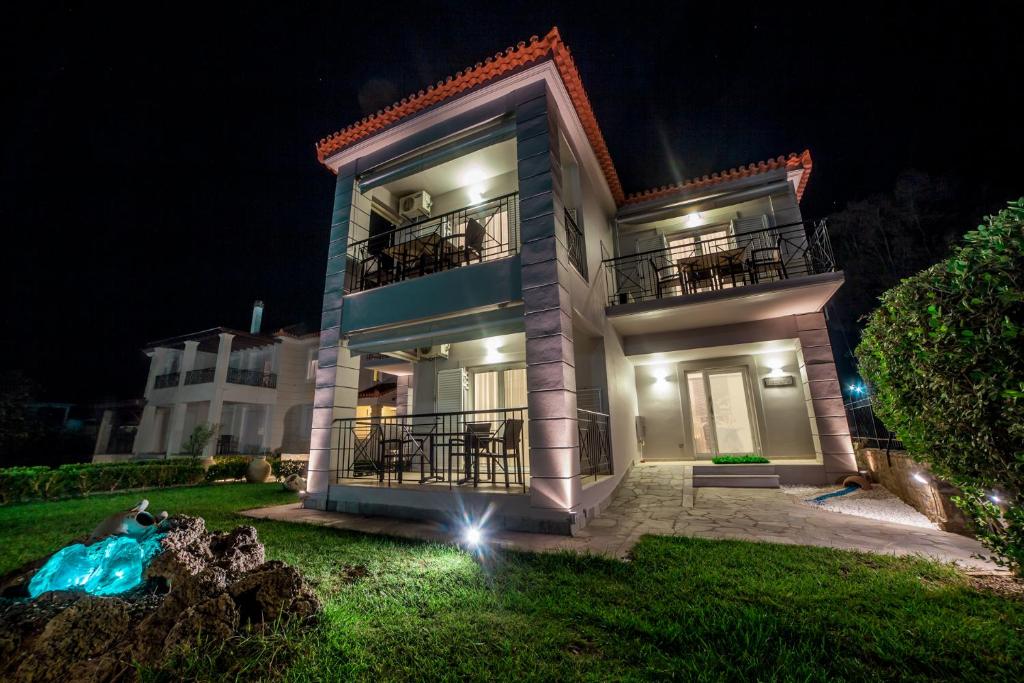 a large house with a balcony at night at Enpy in Finikounta