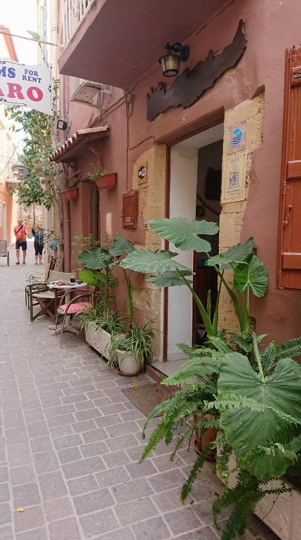a building with tables and plants in front of it at Maro Rooms in Chania
