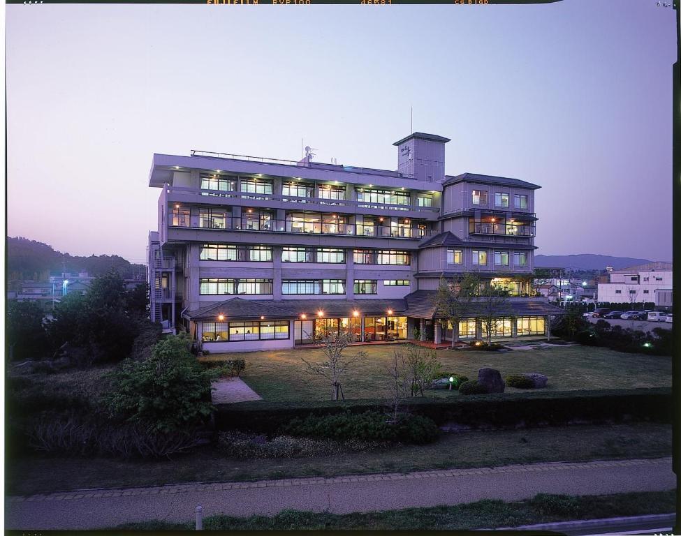 a large building with its lights on at night at Naniwa Issui in Matsue