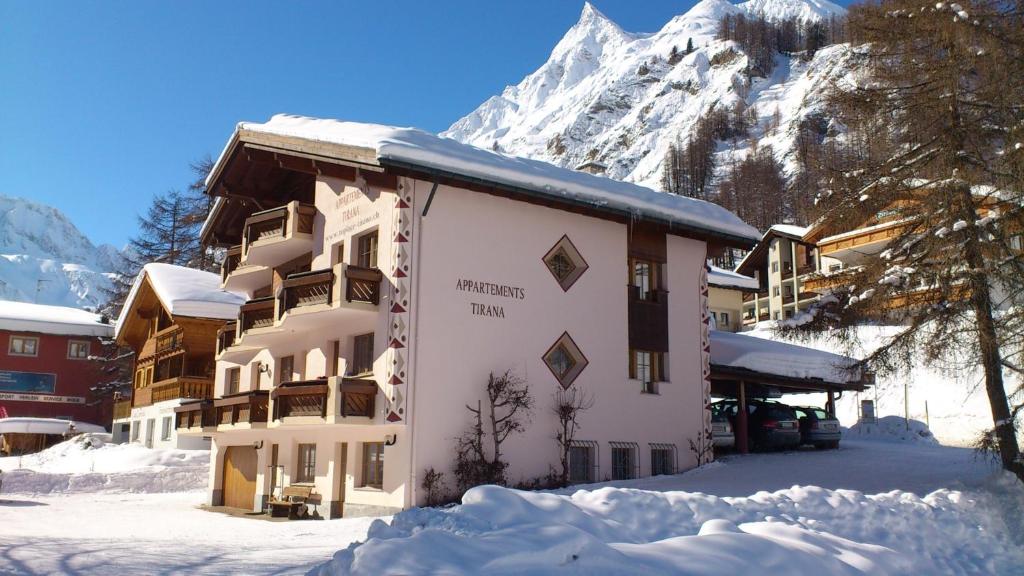 a snow covered building with a mountain in the background at Appartment & Taxi Tirana in Samnaun