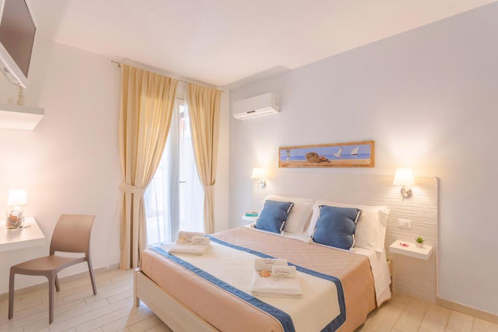 a bedroom with a large bed with blue pillows at Cima Bianca in San Vito lo Capo