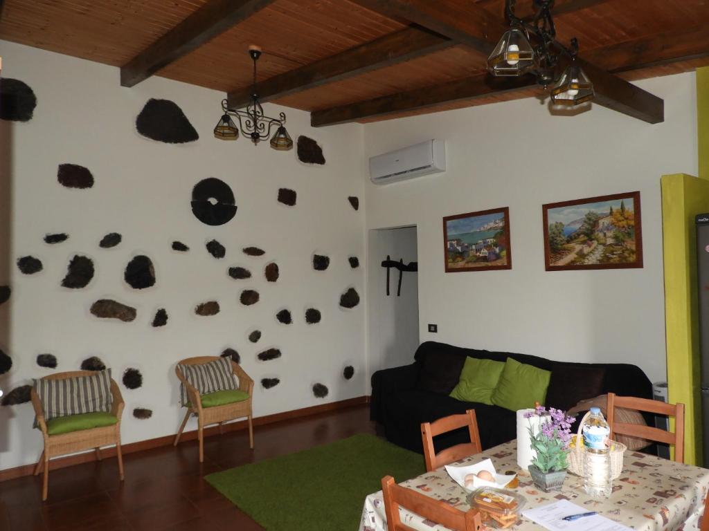 a living room with a black couch and a white wall at La Casa Verde in Las Casas