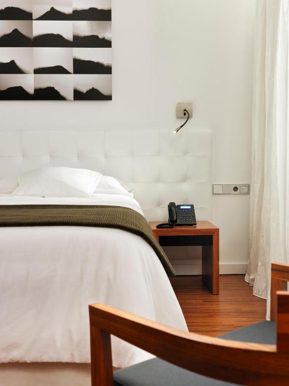 a bedroom with a bed and a phone on a table at Iberostar Heritage Grand Mencey in Santa Cruz de Tenerife