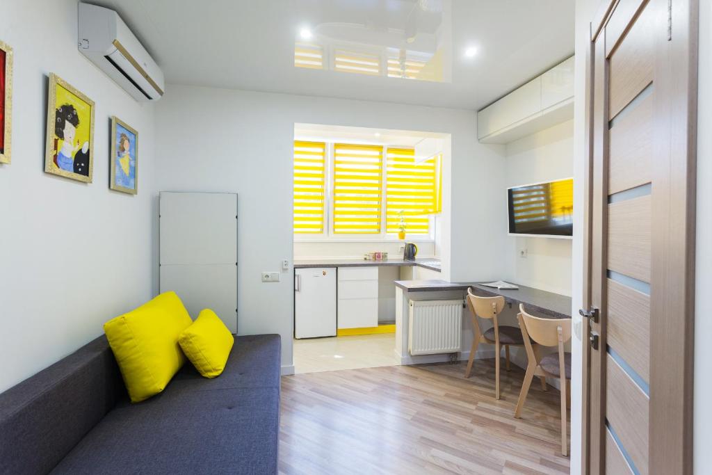 キーウにあるКомфортные мини-апартаменты студио на Ломоносоваのリビングルーム(黄色い枕付)、キッチンが備わります。
