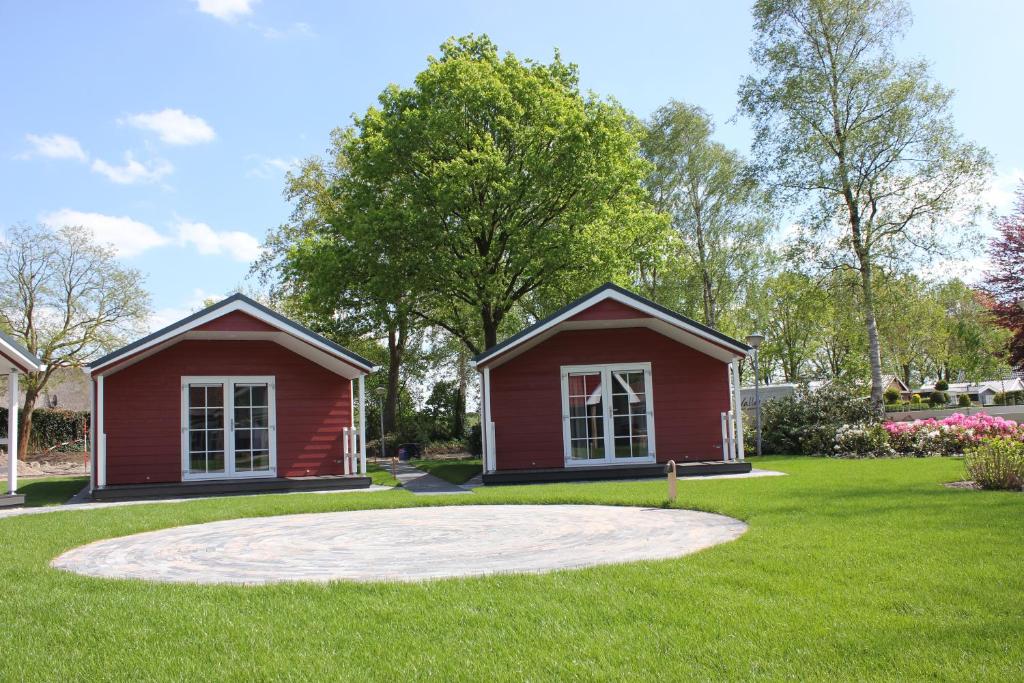 una casa roja en medio de un patio en De Bijsselse Enk, Noors chalet 4, en Nunspeet