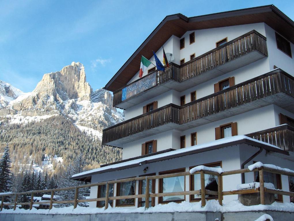 un hotel en las montañas con nieve en el suelo en Hotel Garni Ongaro, en Selva di Cadore