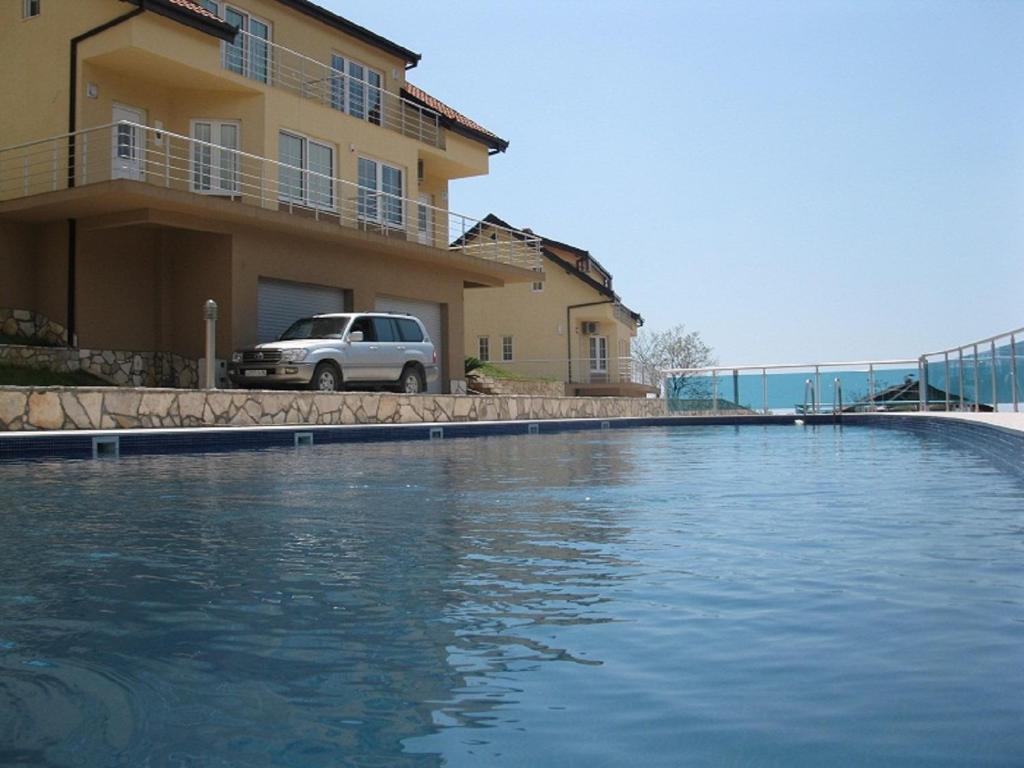 a large pool of water in front of a house at Zubci mountain apartment in Bar