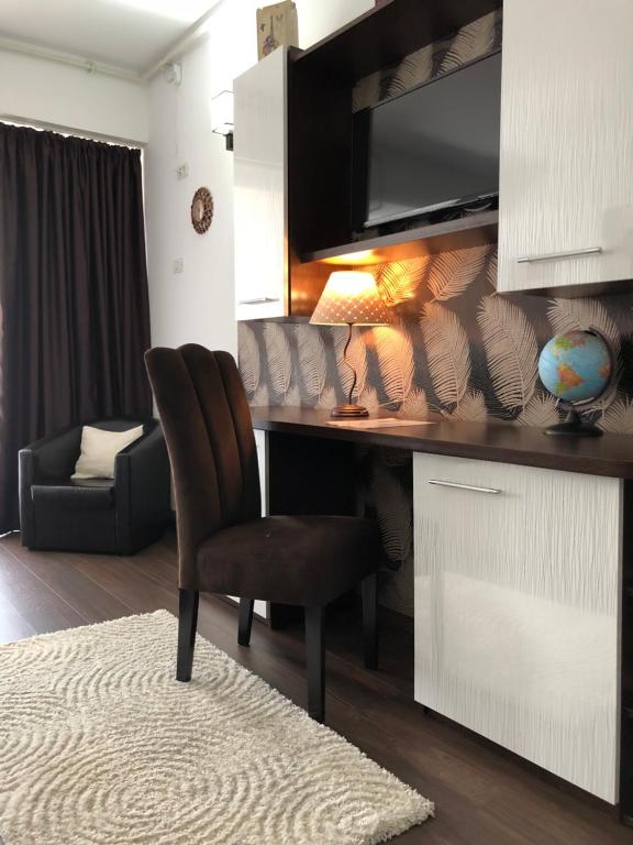 a desk with a chair and a lamp in a room at Vlaicu Apartments in Constanţa