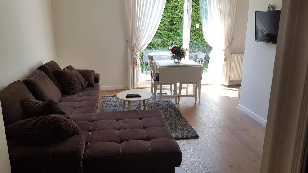 ein Wohnzimmer mit einem Sofa und einem Tisch in der Unterkunft Cozy Garden in Vilnius