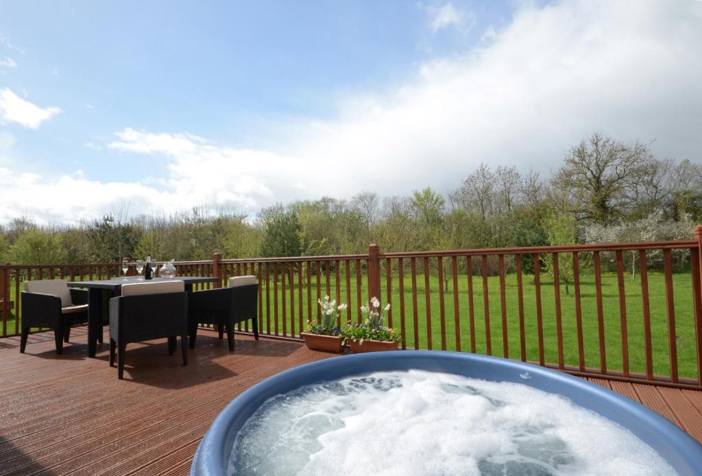 a hot tub on a deck with a table and chairs at Victory Greenland in Amotherby