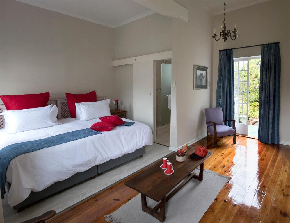 una camera da letto con un grande letto con cuscini rossi di Seven Gables a Port Elizabeth