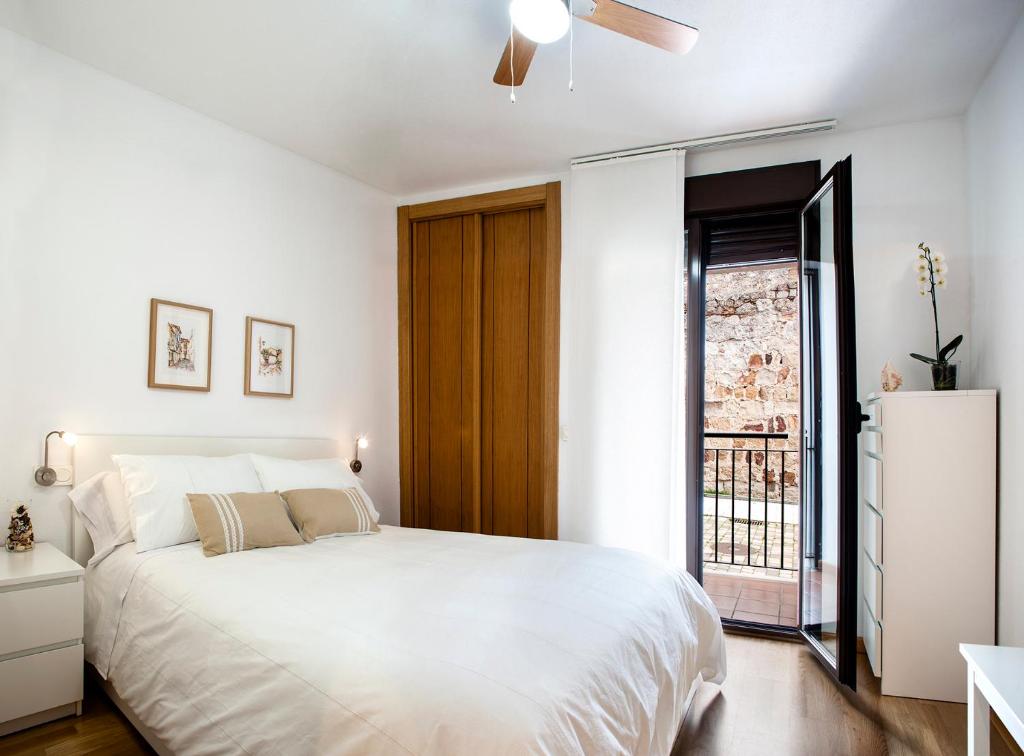 Un dormitorio con una gran cama blanca y una ventana en Yolanda en Zamora