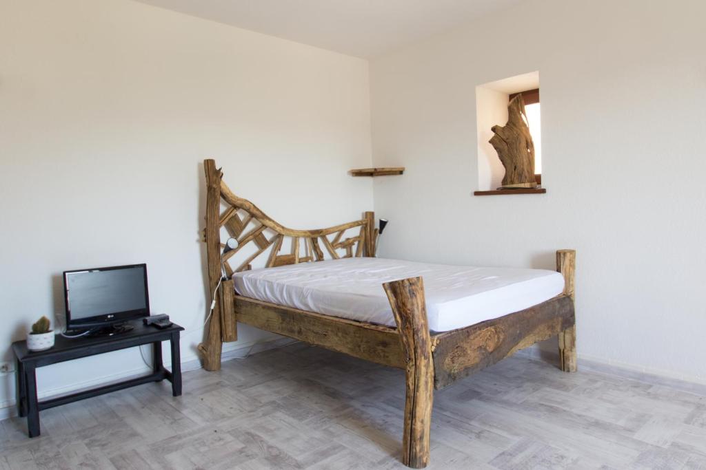 a bedroom with a bed and a tv on a table at Auberge Les Grillons in Meyras