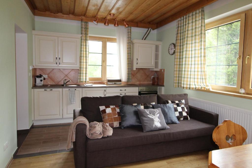 a living room with a couch and a kitchen at HAUS LÄRCHEGG Wellness Apartments in Bad Kleinkirchheim