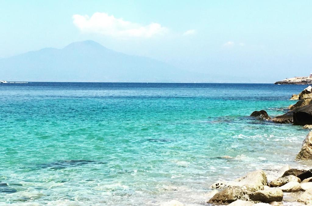 een uitzicht op de oceaan vanaf een rotsachtig strand bij Maison del Mare Sorrento. in Sorrento