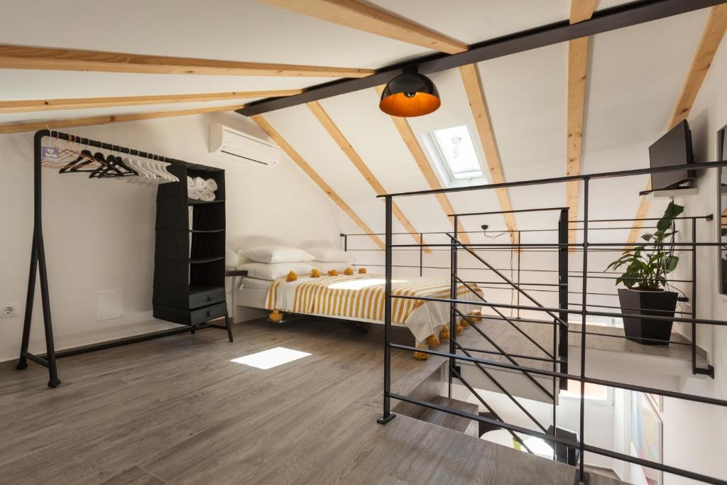 una camera da letto soppalcata con letto e scala a chiocciola di Apartments Stube 4 a Rovigno (Rovinj)