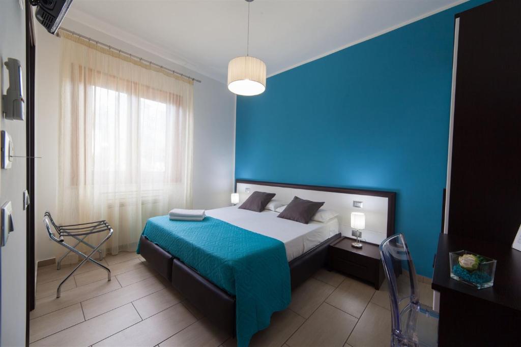 Dormitorio azul con cama y pared azul en Kristal, en San Vito lo Capo