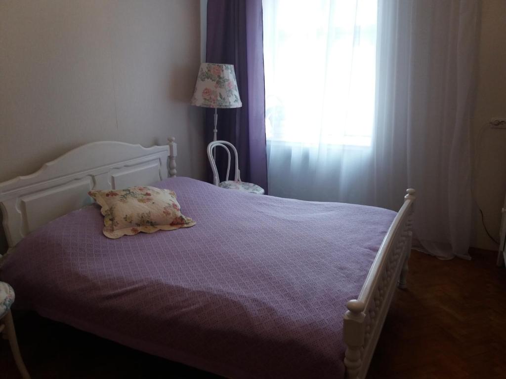 リヴィウにあるApartment - Lesi Ukrainky Streetのベッドルーム1室(紫のシーツが敷かれたベッド1台、窓付)
