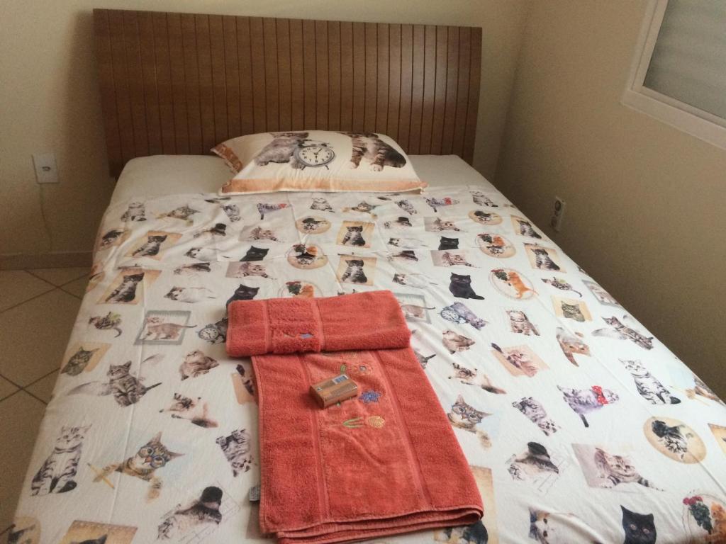 Una cama con una manta con fotos de perros. en Casa da Jussara, en Itaperuna