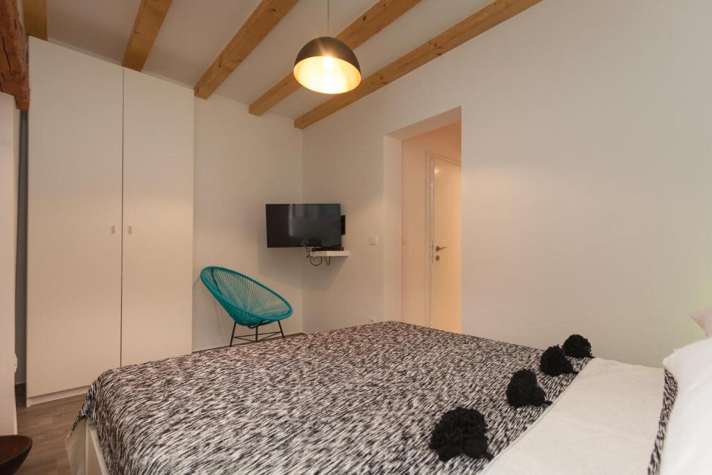 una camera con letto e sedia verde di Apartments Stube 4 a Rovigno (Rovinj)