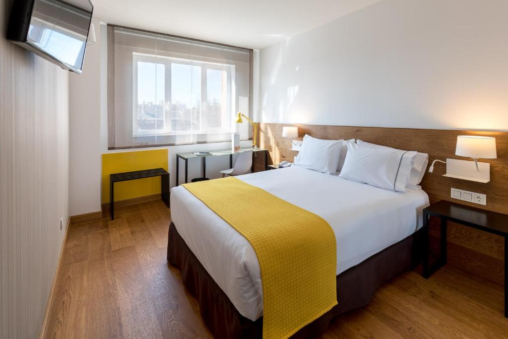 a hotel room with a large bed and a window at Rafaelhoteles Atocha in Madrid