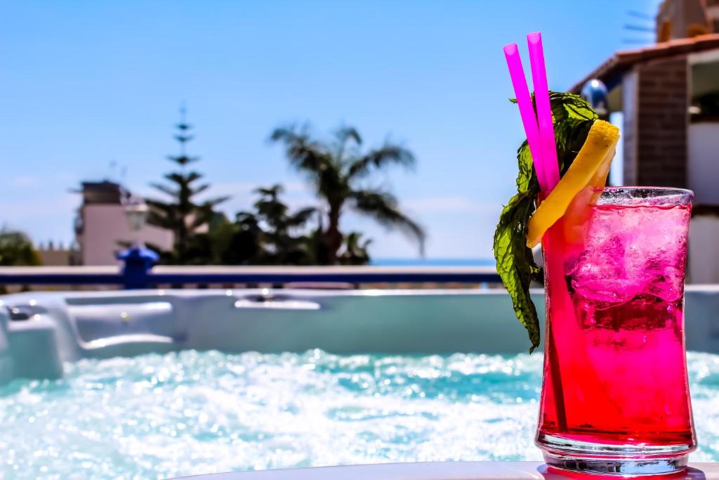 drinka siedzącego na stole obok basenu w obiekcie Princesa Solar 4* - Adults Recommended w mieście Torremolinos