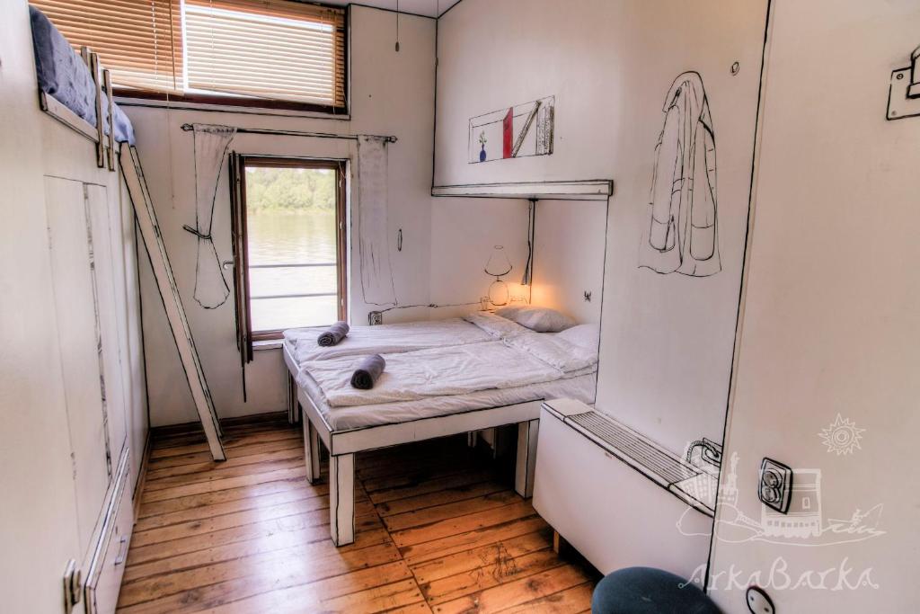 Cette petite chambre comprend un lit et un miroir. dans l'établissement ArkaBarka Floating Hostel, à Belgrade