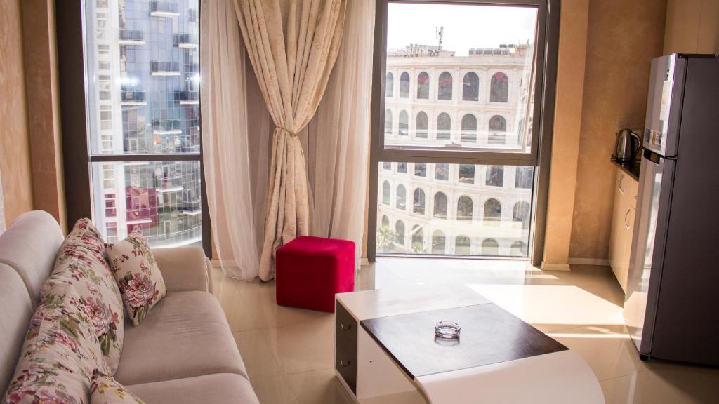 a living room with a couch and a large window at Rock Hotel First Line in Batumi