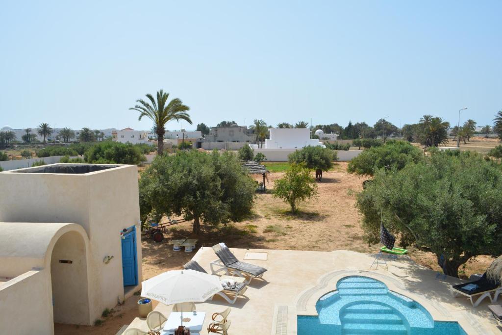 an aerial view of a resort with a pool and trees at Menzel Churasco Djerba in Aghīr