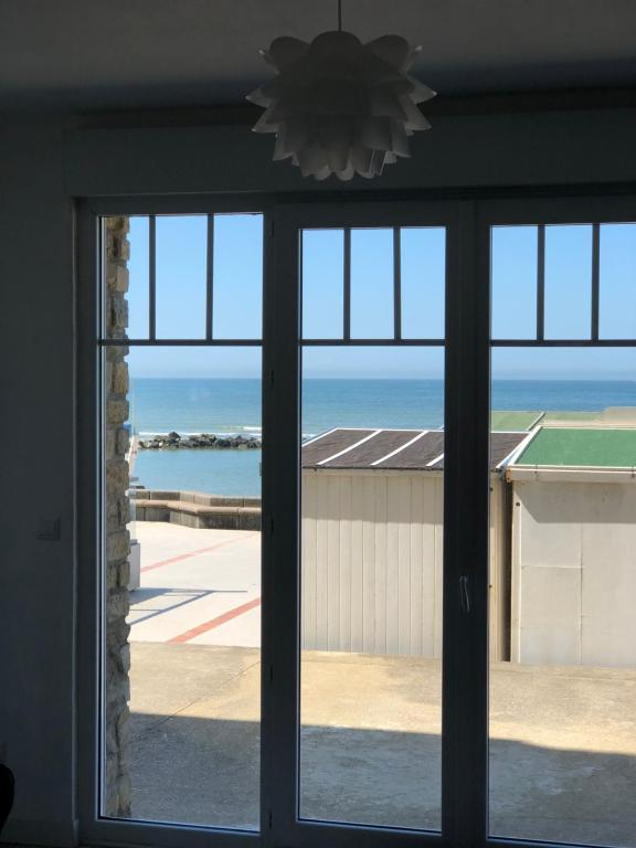 ein Fenster mit Blick auf das Meer durch es hindurch in der Unterkunft Villa Sainte Marguerite in Wimereux