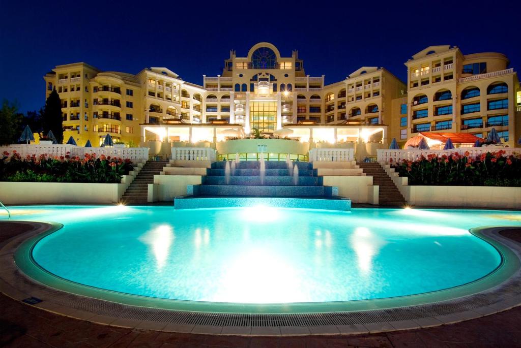 a large pool in front of a hotel at night at Duni Marina Royal Palace Hotel - Ultra All Inclusive in Sozopol