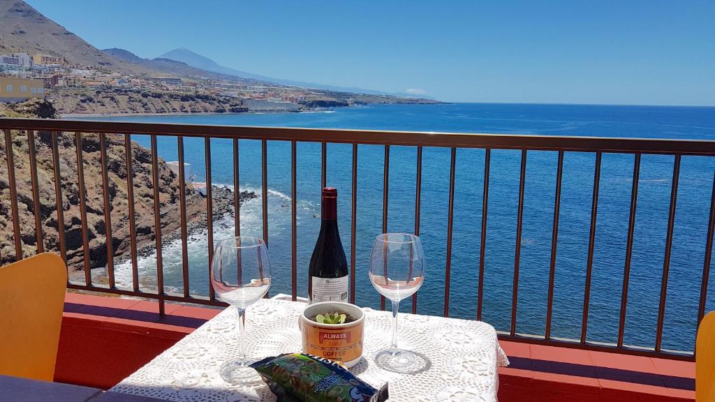 una mesa con 2 copas de vino en el balcón en Hoya Baja 26, en Punta del Hidalgo