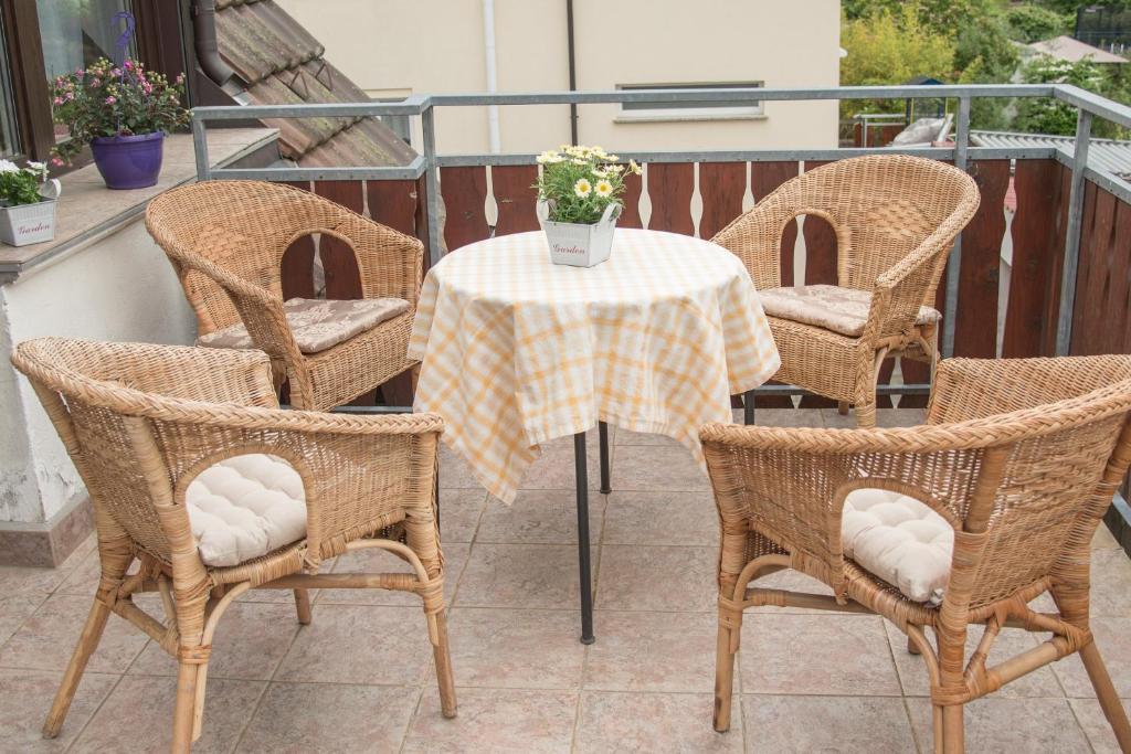 a table with chairs and a table with a vase of flowers at Ferienwohnung "Hirsch Hüsli" in Schopfheim