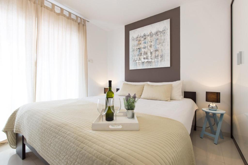 a bedroom with a bed with two bottles of wine on it at Apartments M&T Mirna in Punat