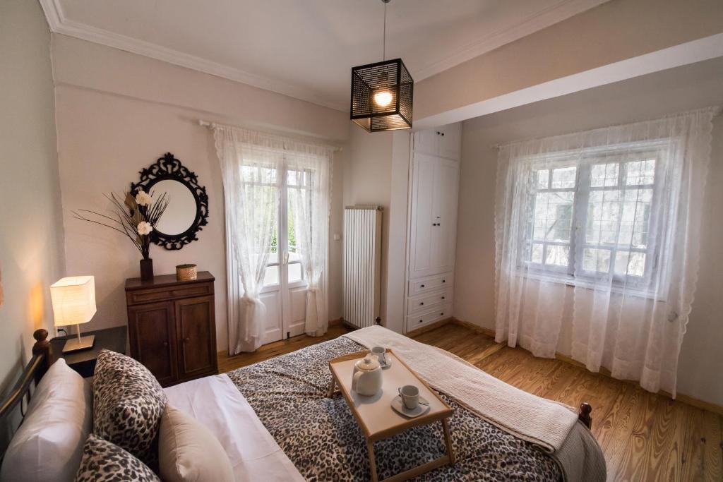 a bedroom with a bed and a couch and windows at La casa di Iro in Lefkada