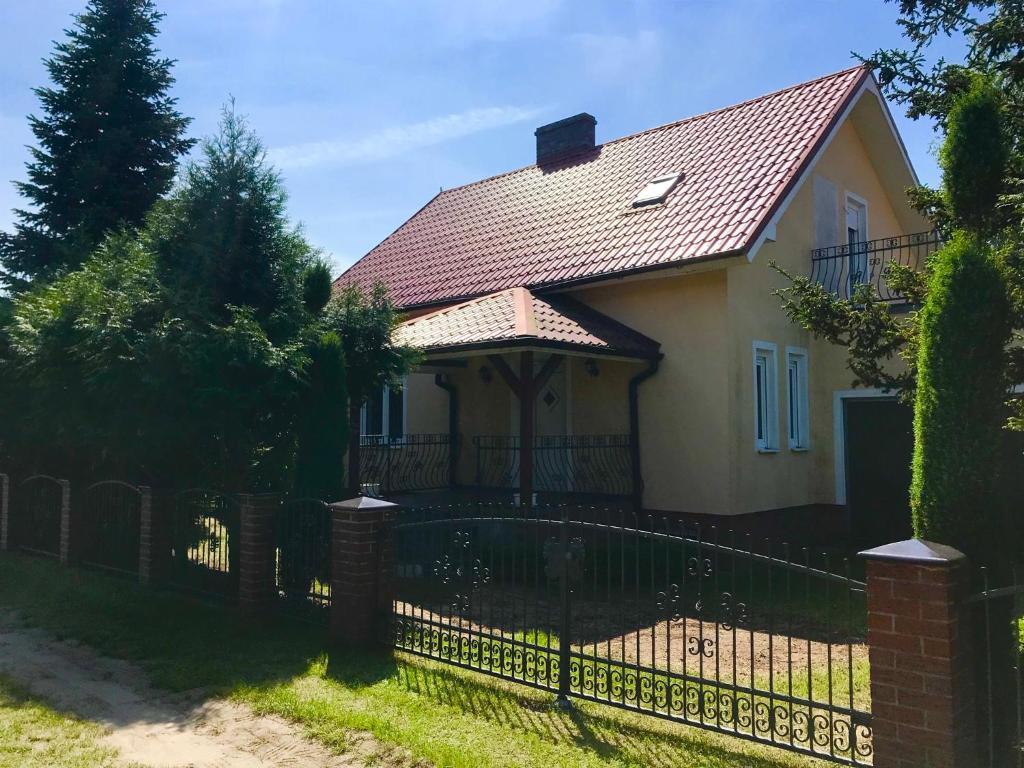 uma casa com uma cerca em frente em Dom Sówka em Radzyń