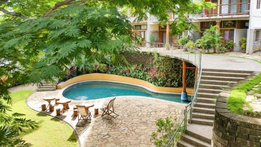 a building with a swimming pool with a staircase and a house at Wicks Getaway - 2bdrm Townhome in San Juan del Sur