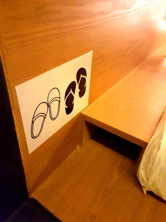 a sign for a pair of shoes on a wooden floor at Sovotel @ Napzone KKIA in Kota Kinabalu