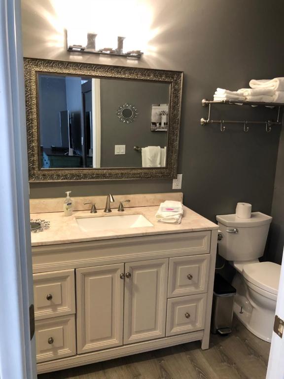 a bathroom with a sink and a mirror and a toilet at New Haven Inn in Solvang