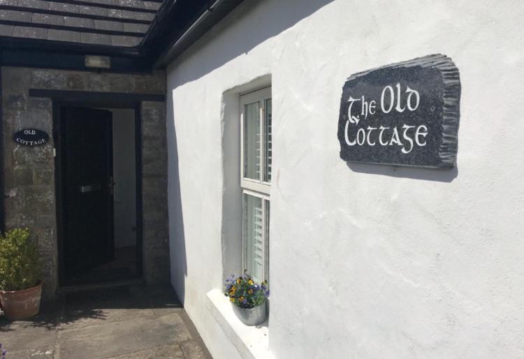 The Old Cottage في دولين: علامة على جانب مبنى أبيض