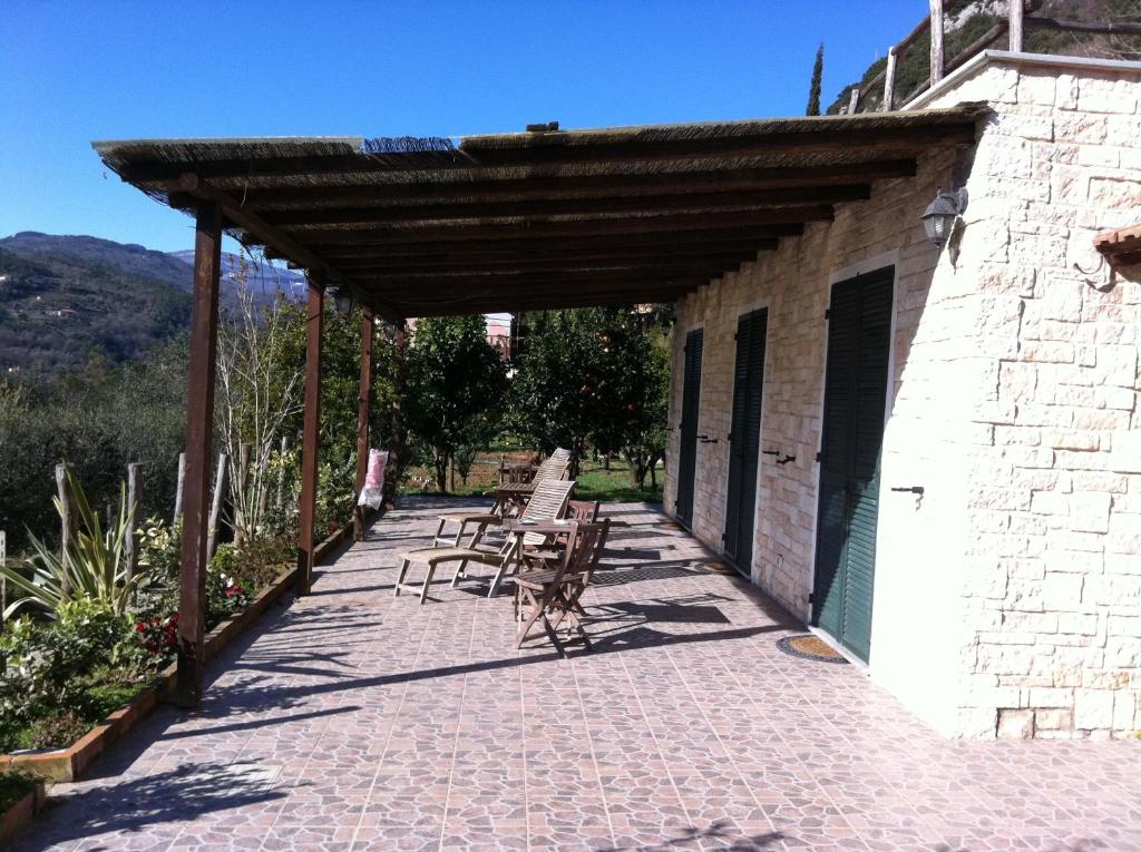 un patio con mesas y sillas en un edificio en Agriturismo La Rocca di Perti, en Finale Ligure